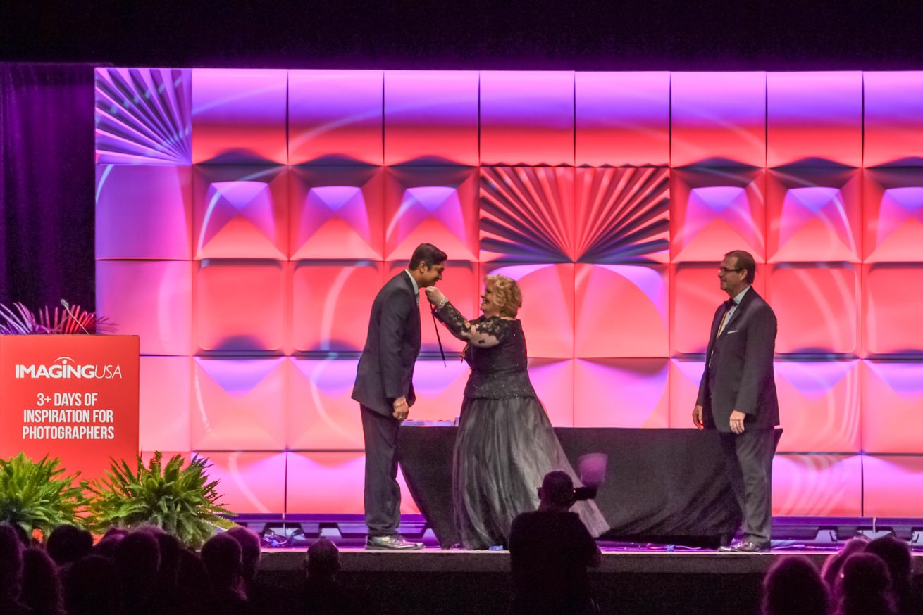 Anand Jayaraman receiving degree from Sponsor Sally Kolar, M. Photog, CPP.  Image Credit - Melissa Gordon